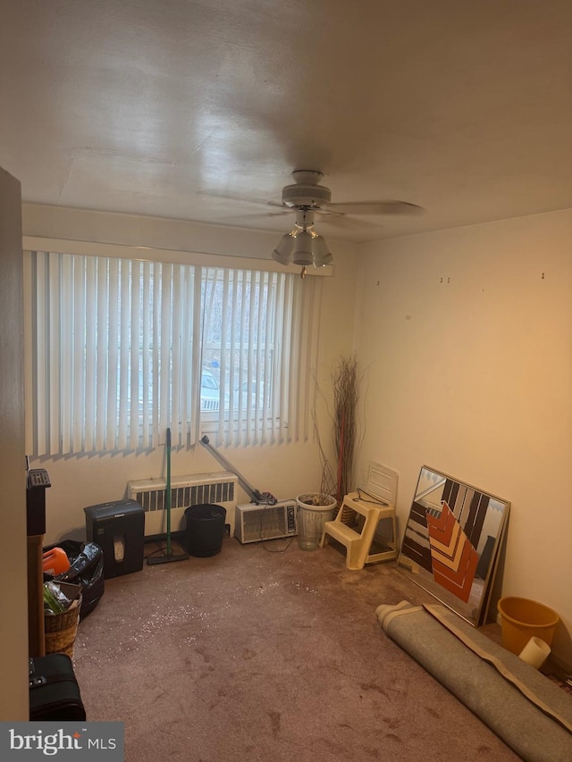 recreation room with ceiling fan, carpet floors, and radiator heating unit