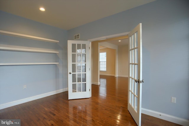 unfurnished room featuring french doors and dark wood-type flooring