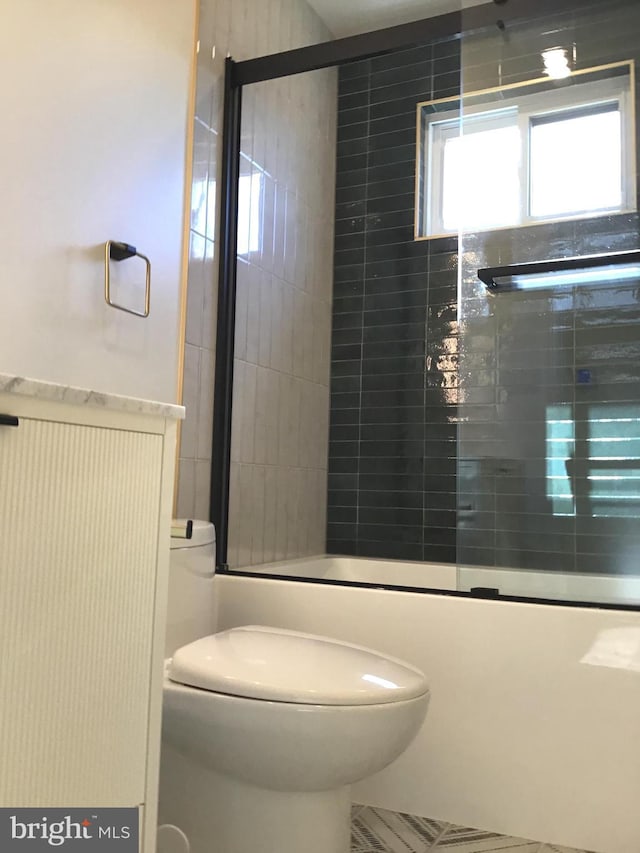 bathroom featuring toilet and enclosed tub / shower combo