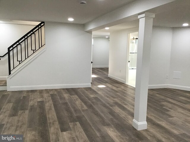 basement with dark hardwood / wood-style floors