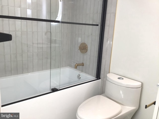 bathroom with toilet and combined bath / shower with glass door