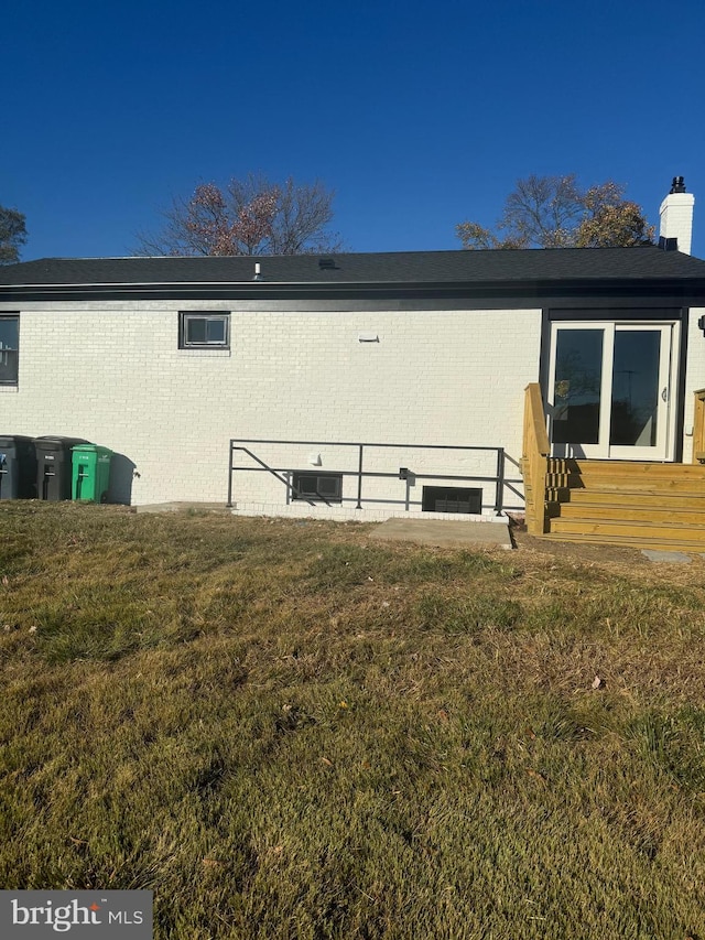 rear view of property with a lawn