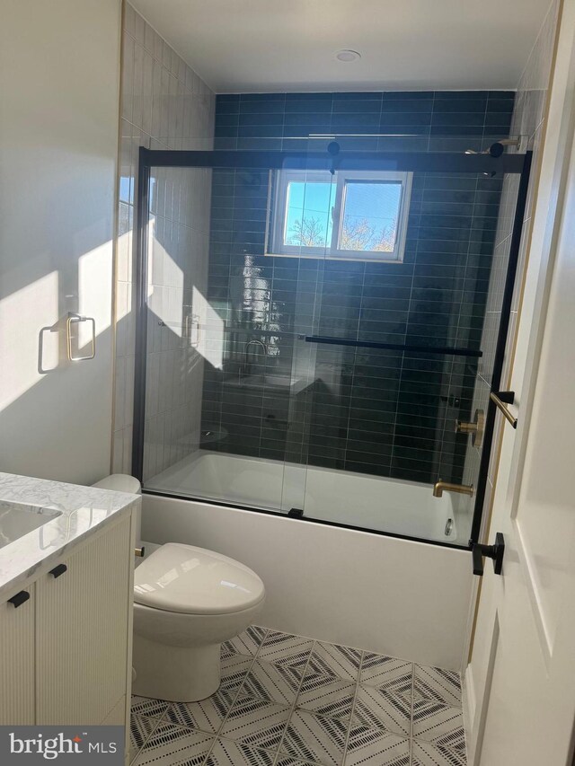 full bathroom featuring shower / bath combination with glass door, vanity, and toilet