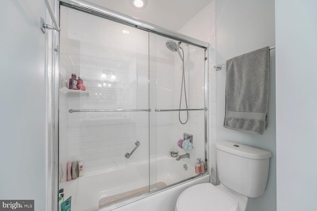 bathroom with combined bath / shower with glass door and toilet