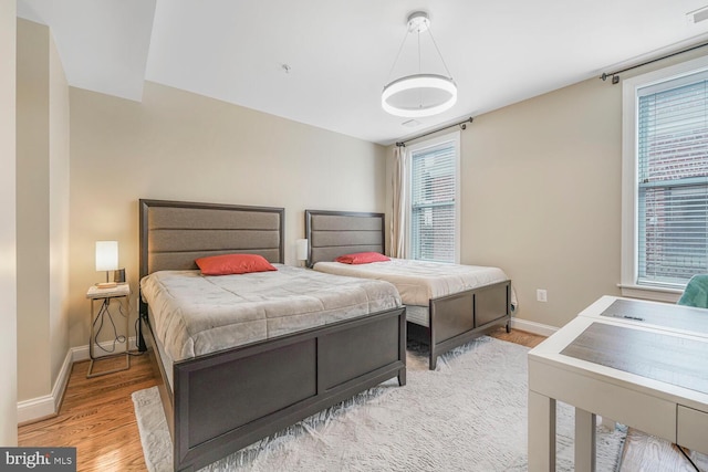 bedroom featuring visible vents, baseboards, and light wood-type flooring