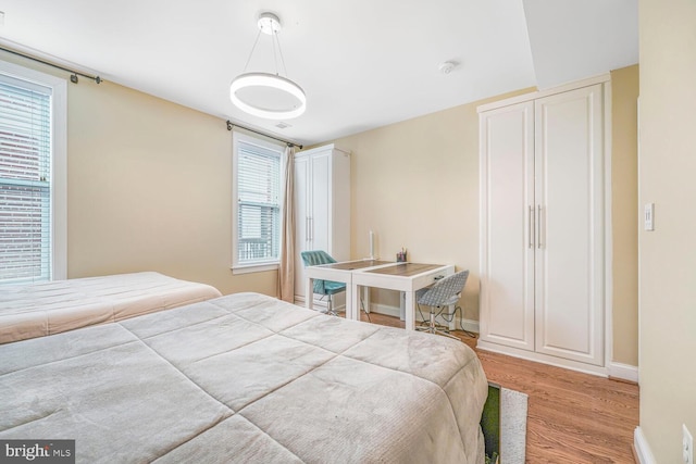 bedroom featuring baseboards and wood finished floors