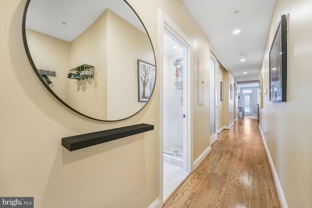 hallway featuring recessed lighting, wood finished floors, and baseboards