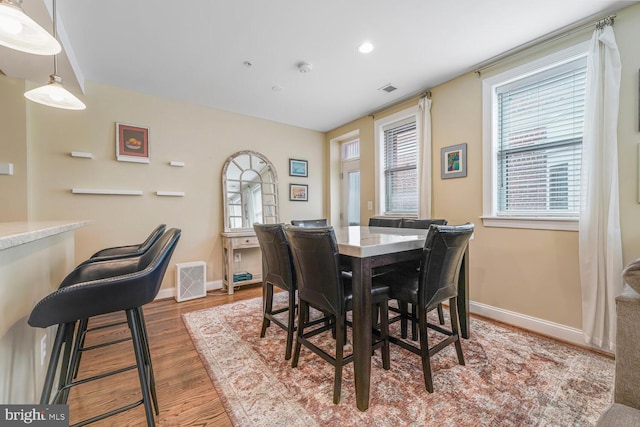 dining room with visible vents, wood finished floors, and baseboards