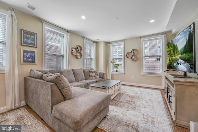 living area with recessed lighting, light wood-style floors, and baseboards