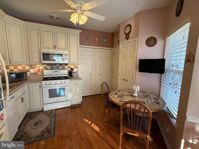 kitchen with dark hardwood / wood-style flooring, white appliances, decorative backsplash, and ceiling fan