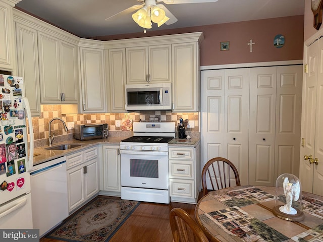 kitchen featuring sink, white appliances, ceiling fan, dark hardwood / wood-style flooring, and decorative backsplash