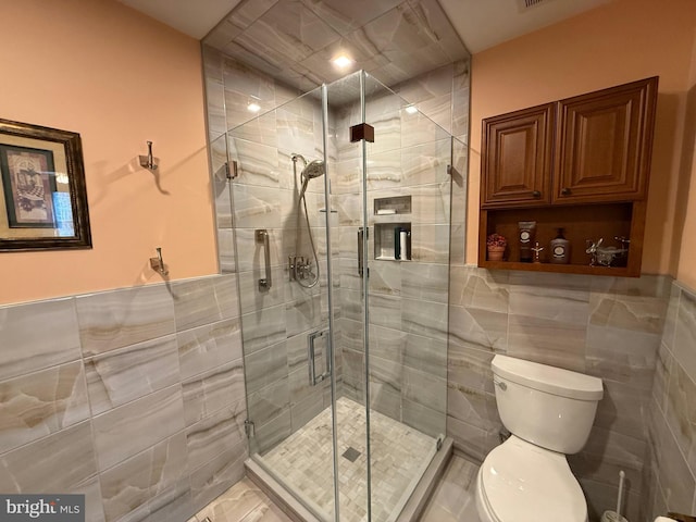 bathroom featuring tile walls, an enclosed shower, and toilet