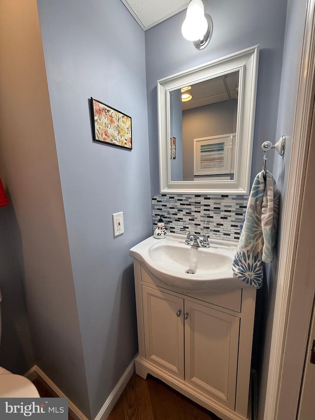 bathroom featuring vanity, backsplash, and hardwood / wood-style floors