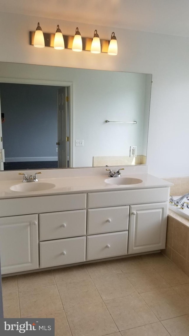 bathroom with tiled bath, tile patterned flooring, and vanity