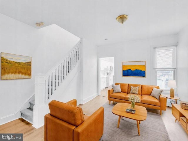 living room with sink and light hardwood / wood-style flooring