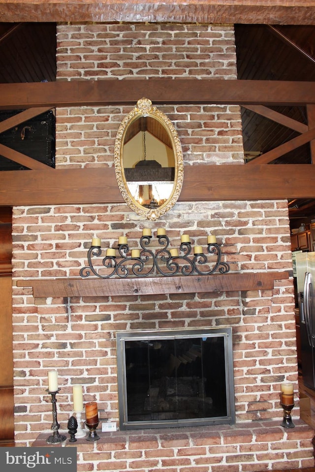 room details with a brick fireplace and stainless steel fridge