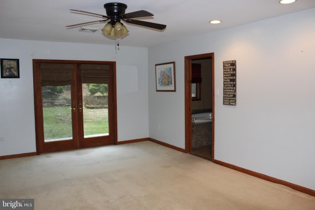 spare room featuring ceiling fan, light colored carpet, and french doors