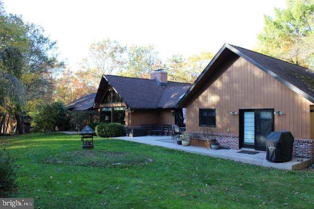 rear view of house with a lawn and a patio area