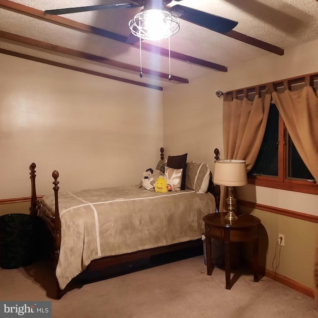 bedroom featuring ceiling fan, carpet, and beam ceiling