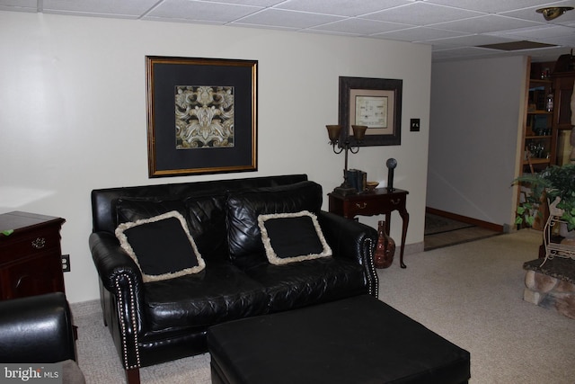 living room featuring a drop ceiling and carpet flooring