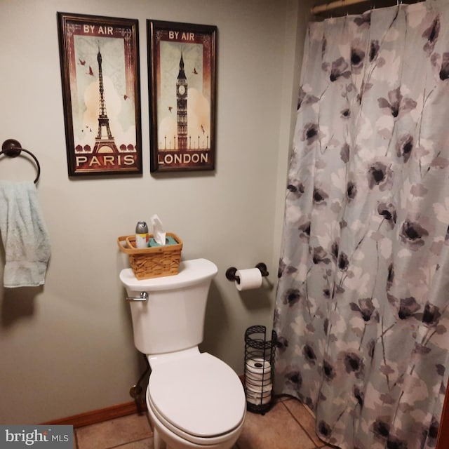 bathroom featuring toilet, tile patterned flooring, and a shower with curtain