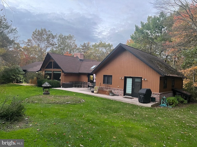 rear view of house with a yard and a patio