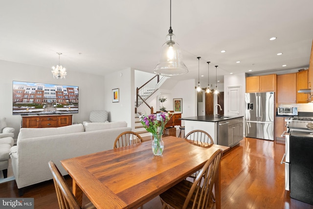 dining area with an inviting chandelier, dark hardwood / wood-style flooring, and sink