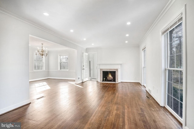 unfurnished living room featuring an inviting chandelier, a fireplace, ornamental molding, and dark hardwood / wood-style floors