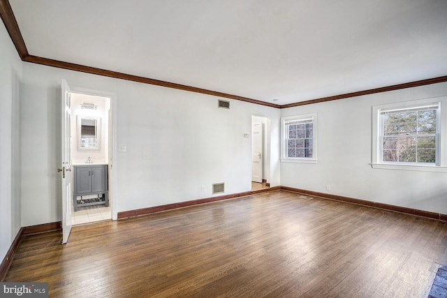 unfurnished room with hardwood / wood-style flooring, crown molding, and sink