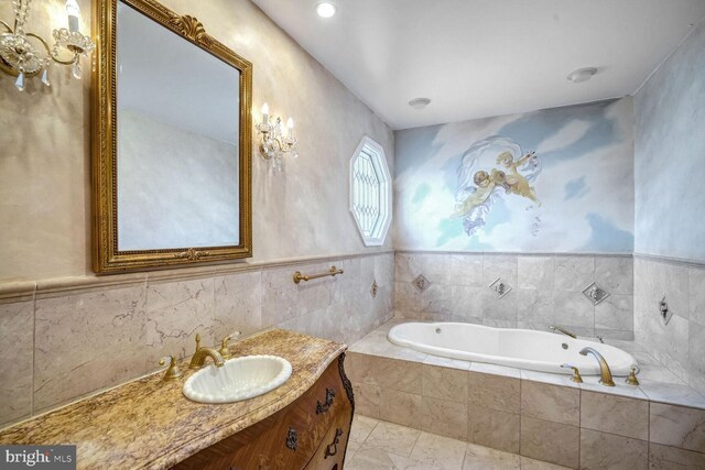 bathroom featuring vanity and tiled bath