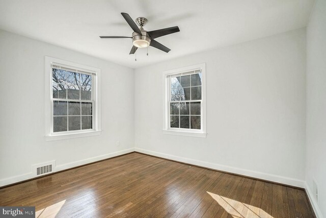 unfurnished room with ceiling fan, a wealth of natural light, and dark hardwood / wood-style flooring