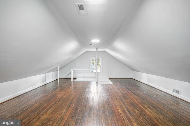 additional living space with vaulted ceiling and dark hardwood / wood-style flooring