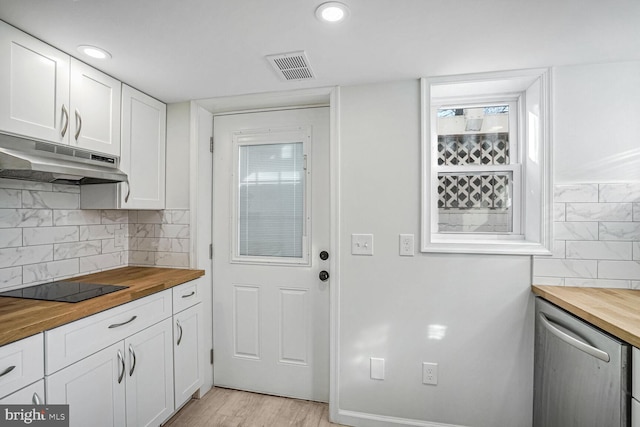 kitchen with black electric cooktop, white cabinets, and wood counters