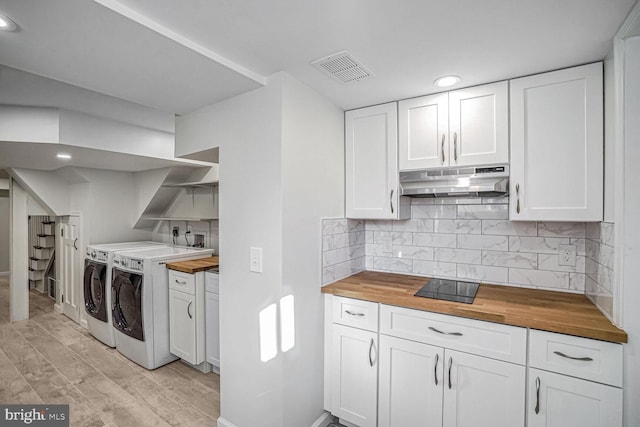 kitchen with independent washer and dryer, wood counters, and white cabinets