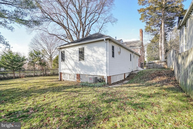 view of home's exterior with a yard and central AC