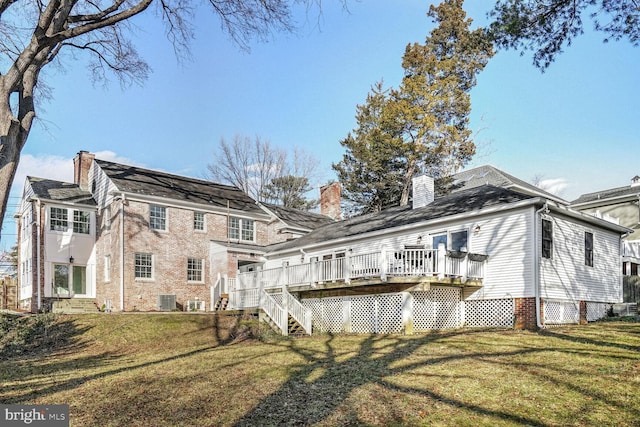 back of property featuring a wooden deck, a yard, and central AC