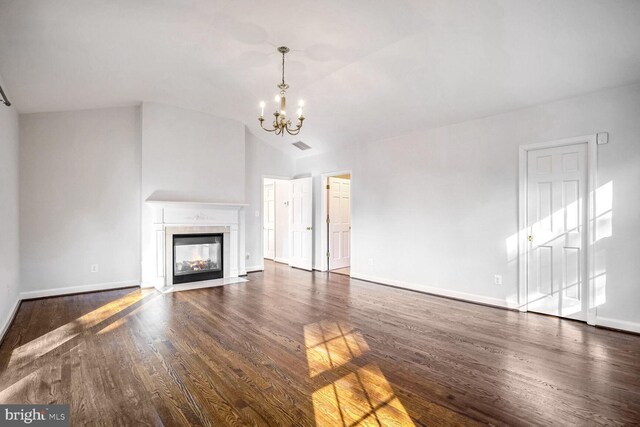 unfurnished living room featuring a multi sided fireplace, vaulted ceiling, a notable chandelier, and dark hardwood / wood-style flooring