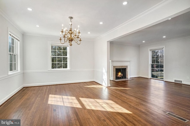 unfurnished living room with hardwood / wood-style flooring, ornamental molding, a fireplace, and an inviting chandelier