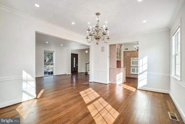 interior space featuring a notable chandelier, dark wood-type flooring, and ornamental molding