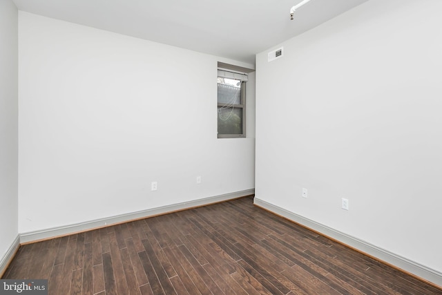 spare room featuring dark wood-type flooring