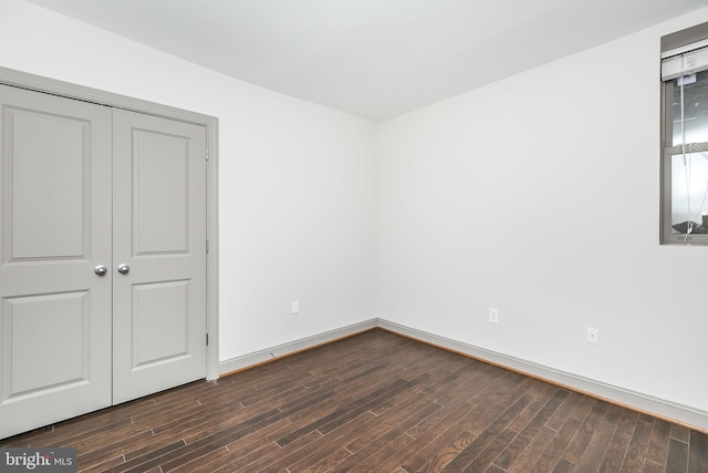 unfurnished bedroom featuring dark hardwood / wood-style floors and a closet