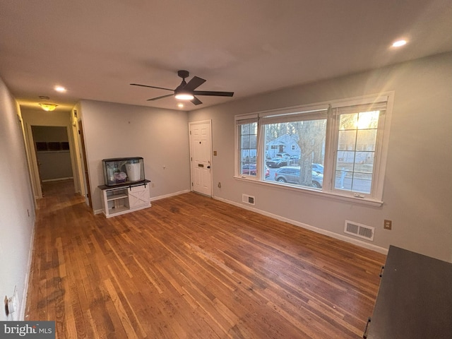 unfurnished living room featuring ceiling fan and hardwood / wood-style floors