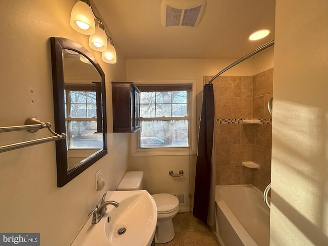 full bathroom featuring shower / bathtub combination with curtain, sink, plenty of natural light, and toilet