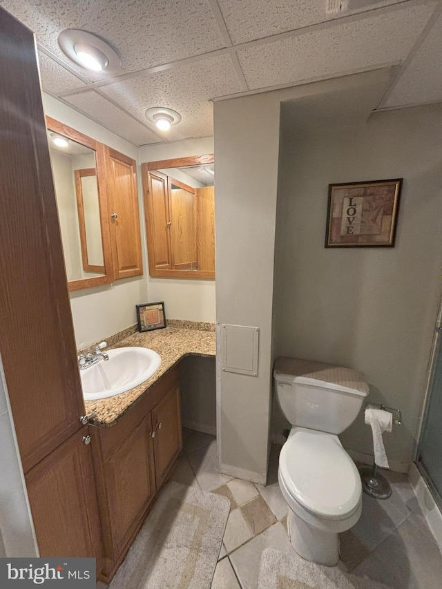 bathroom featuring vanity, a paneled ceiling, and toilet