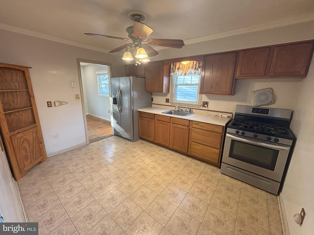 kitchen with ornamental molding, appliances with stainless steel finishes, sink, and ceiling fan