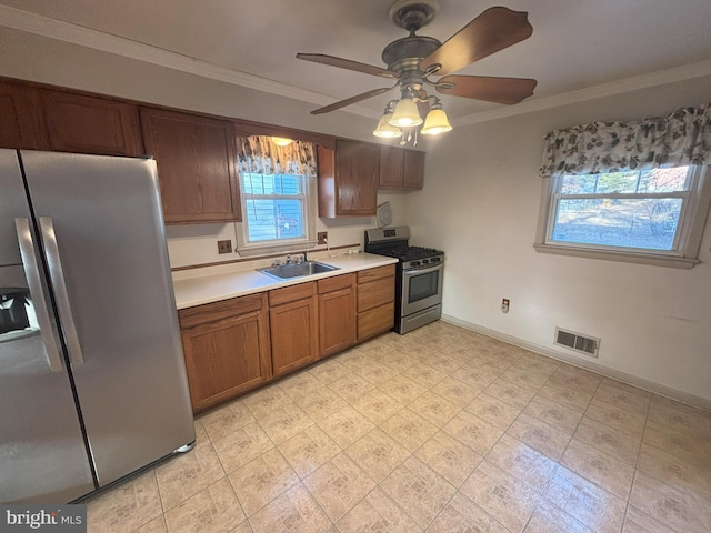 kitchen featuring ornamental molding, appliances with stainless steel finishes, sink, and ceiling fan