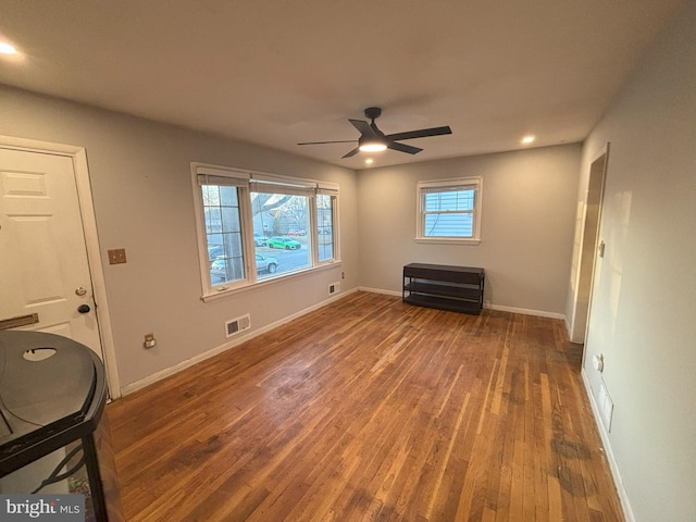 empty room with dark wood-type flooring and ceiling fan