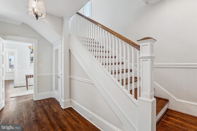 stairway featuring hardwood / wood-style floors and a notable chandelier