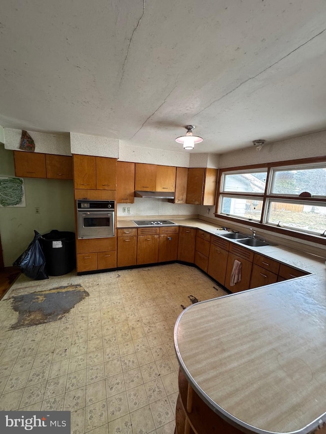 kitchen featuring sink, black electric stovetop, and stainless steel oven