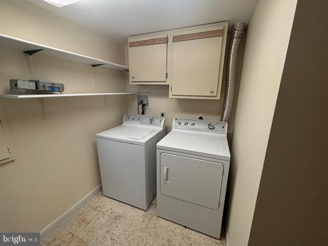 washroom with cabinets and washer and dryer